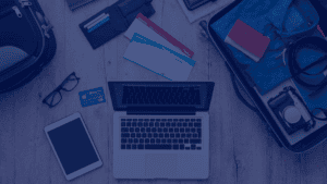 A top-down shot reveals a laptop, tablet, and smartphone alongside boarding passes, wallets, glasses, and a packed suitcase on a light wooden surface. The arrangement conveys a sense of preparation for a journey, blending technology with traditional travel items. The open laptop and other devices suggests planning and connectivity on the go. The photo's bright lighting and organized composition lends itself well to concepts such as travel planning, digital nomadism, technology integration, and vacation preparation. Its neutral tones and clear imagery make it suitable for use in travel blogs, technology websites, or marketing materials for travel agencies.