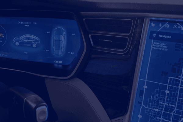 A close-up shot shows the interior of a car, featuring two illuminated screens. The left screen displays a graphic of a blue car along with some metrics. The screen on the right shows a navigation map. The interior is sleek with an aesthetic finish. This photograph could be used for projects about travel and technology, car interiors, navigation systems, and vehicle design.