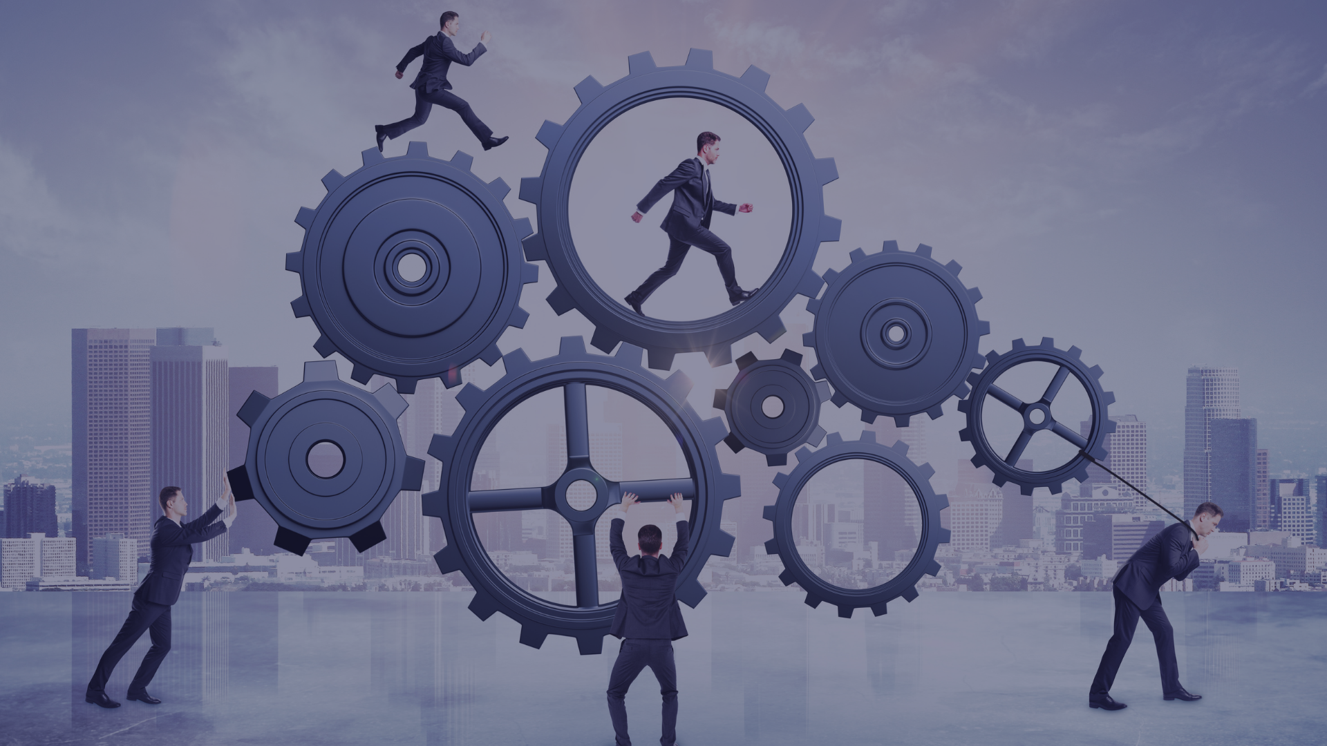 Five sharply dressed men with short brown hair are seen working with giant gears in an urban setting during the day. They are showing engineering productivity and engineering capability. One pushes a gear, another pulls a gear with a rope, one balances a gear on their back, one is running inside the gear, and another is running on top of the gear. This image has a sophisticated mood and could be used in projects about teamwork, business, and corporate operations.